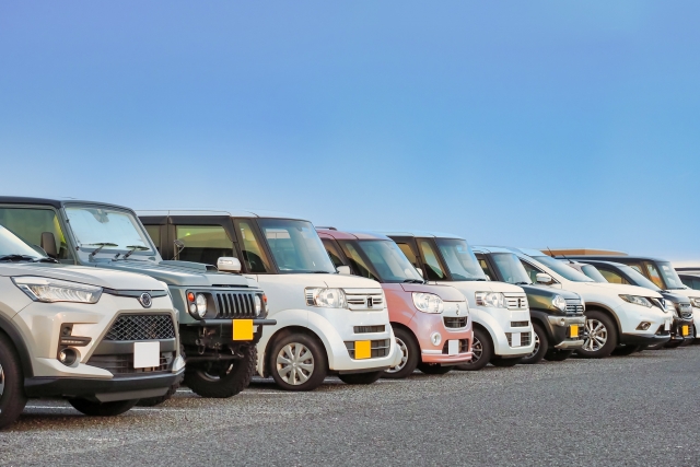 駐車場に一列に並んだ色とりどりの軽自動車。