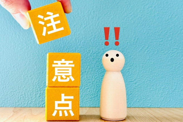 「注意点」と書かれた積み木と驚く木製の人形。
